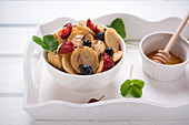 Vegan mini pancake bowl with berries, sugar syrup and chocolate