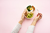 Frauenhände halten Lunchbox mit gesunden Snacks