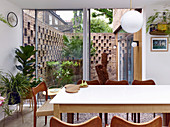 Blick vom Esszimmer in kleinen Innenhofgarten mit dekorativen Backsteinwänden
