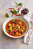 Roasted pepper soup with noodles, olives and chilli