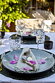 Summer table setting with mussel shells and rose petals