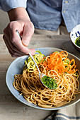 Pour pesto over wholemeal spaghetti with vegetable spirelli