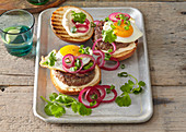 Burger with fried egg and red onions