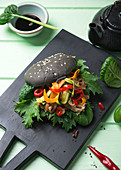 Veganer schwarzer Burger mit Mock Duck, Asiasalat und Grillgemüse