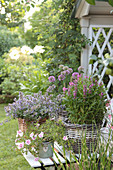 Arrangement with catmint, purple loosestrife, petunias, and ornamental leeks in baskets