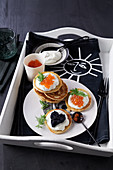 Blinis with caviar and sour cream on tray