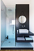 Small bathroom with narrow shower area and black tiles