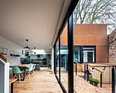 Modernes Architektenhaus mit rostiger Fassade und offenem Wohnraum