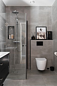 Shower cubicle in bathroom with grey tiles