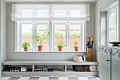 Shoe rack below window in pale grey foyer