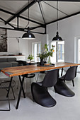 Rustikaler Esstisch mit Klassikerstühlen in offenem Wohnraum