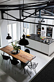 Rustikaler Esstisch mit Klassikerstühlen in offener Küche mit Kücheninsel