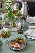 Brote mit Stoffbändern auf gedecktem Tisch mit Blumendeko