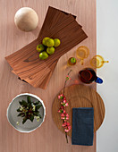 Bowl made from wooden veneer, crockery and decorations on table