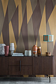 Dark wooden sideboard against wall with brown retro pattern