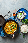 Keralan chicken curry in coconut milk with potatoes and coriander, rice and mint raita