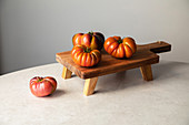 Composition with raw red tomatoes arranged on wooden board on marble table
