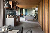 Blick über Esstisch auf Küchenzeile, im Hintergrund Sitzbereich im offenen Wohnraum