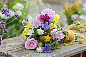 Colorful summer bouquet of mallows, roses, bluebells, scabious, St. John's wort, gooseberries and evening primrose