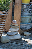Pebbles laid on top of each other as cairns with snail shell as decoration