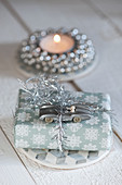 Weihnachtsgeschenk mit silbernem Rennauto als Dekoration