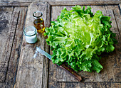 Endive salad on a wooden background with a knife, oil carafe and salt