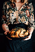 Woman holding roasted taragon garlic chicken