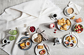 Frühstückstisch mit Granola, frischen Früchten, Smoothies und pikantem Gebäck