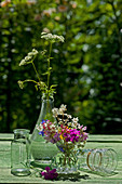 Colourful summer posy and flowers of greater burnet-saxifrage in bottle