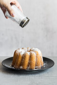 Dusting bundt cake with powdered sugar