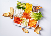A platter of raw vegetables with an anchovy and garlic dip and grilled bread