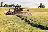 Tractor raking hay