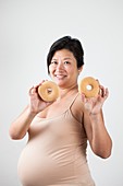 Pregnant woman holding doughnuts