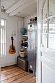 Jungenzimmer mit grauem Kleiderspind, Regal und Gitarre an der Wand