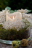 Wreath of Queen Anne's lace flowers arranged around candle lantern