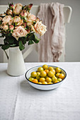 Green plums in a bowl on a kitchen table