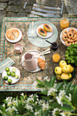 Fruit and pastries on breakfast table in garden