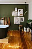 Comfortable bathroom with wooden floor and green accent wall
