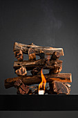 Grillfeuer aus übereinander gestapelten Holzscheiten