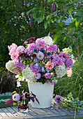 Fragrant late summer bouquet with phlox, dahlias, hydrangeas, roses, bluebells, amaranth, sweet peas and thistles in a stable vase