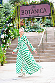 A grey-haired woman wearing a polka-dot maxi dress