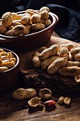 Group of peanuts on wooden boards and spoon with peanut butter