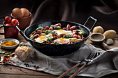 Pan with fried eggs with traditional Spanish chorizo sausages and green peppers