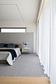 Modern bedroom in pale grey with panelled walls