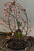 Ikebana arrangement of Bodnant viburnum twigs and hyacinth in glass jar