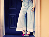 A woman wearing light Marlen trousers and platform sandals