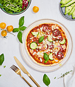 Pizza with zucchini, tomatoes, oregano, basil and parmesan