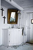 Corner sink with white, fitted wooden surround in rustic, country-house-style bathroom