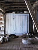 Bodenkissen, Felle und Sitzpouf im rustikalen alten Holzhaus