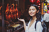 Young woman in Chinatown (Bangkok) with Peking ducks